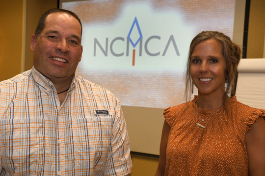 Two people smiling and posing for a picture at NCMCA