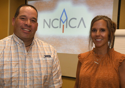 Two people smiling and posing for a picture at NCMCA